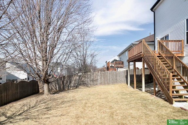 view of yard with a deck, stairway, a gate, and fence