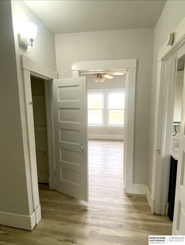 hallway with baseboards and light wood-style floors