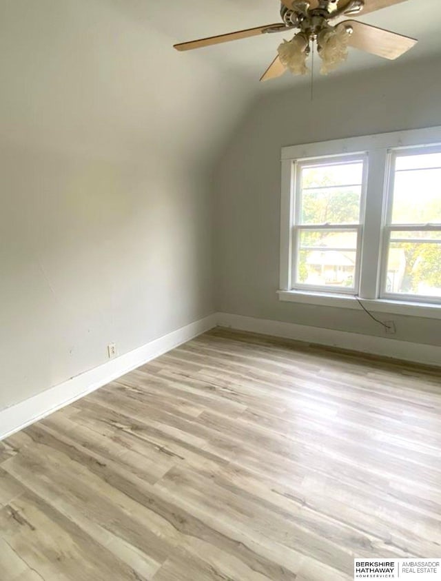 additional living space featuring light wood-type flooring, baseboards, a healthy amount of sunlight, and a ceiling fan