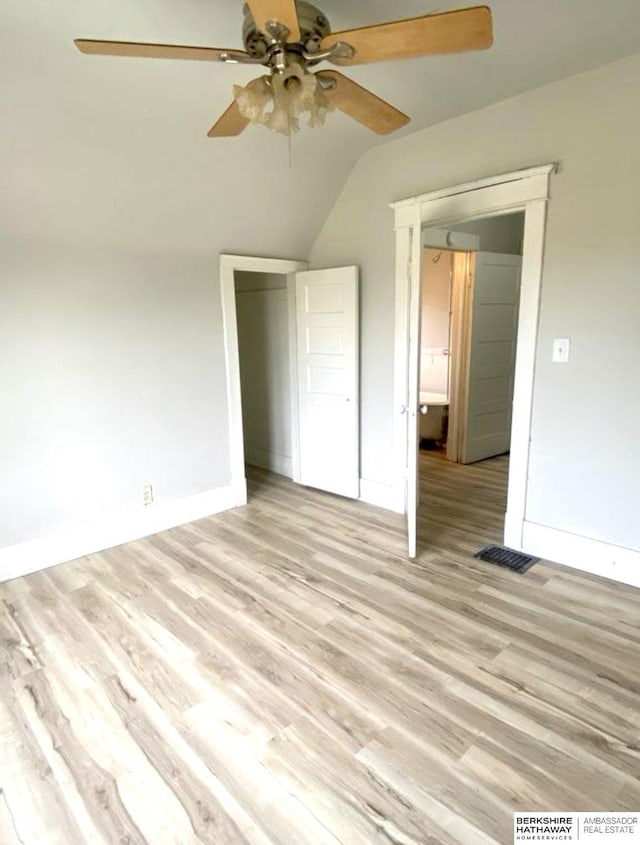 unfurnished bedroom with baseboards, light wood-style flooring, a ceiling fan, and vaulted ceiling