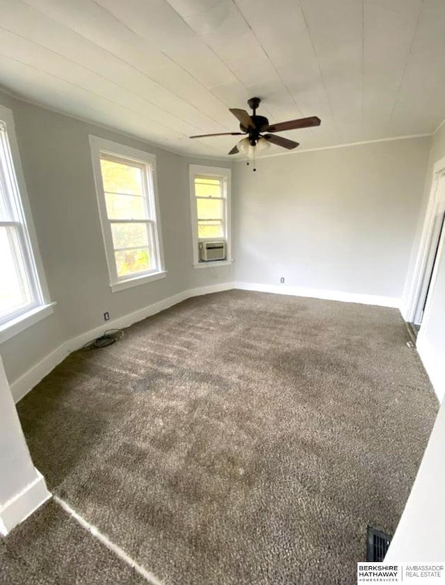 carpeted spare room featuring cooling unit, baseboards, and a ceiling fan