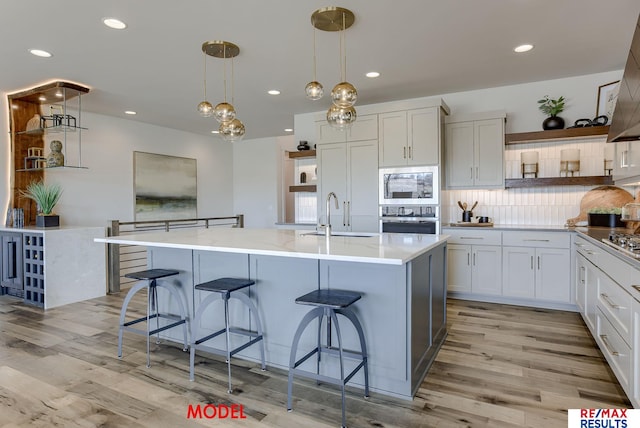 kitchen with open shelves, a breakfast bar area, and stainless steel appliances