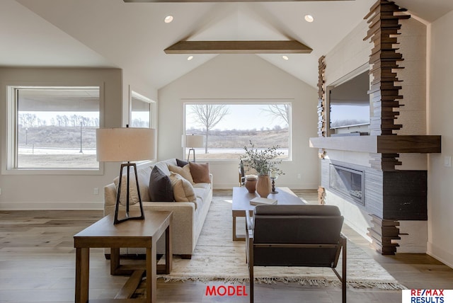 living room featuring wood finished floors, baseboards, lofted ceiling with beams, a fireplace, and recessed lighting