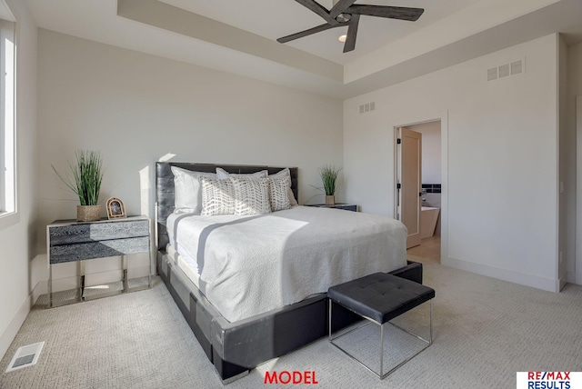 bedroom featuring visible vents, a raised ceiling, and baseboards