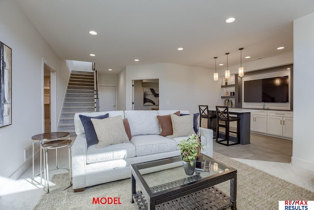 living area featuring stairs, recessed lighting, visible vents, and light carpet