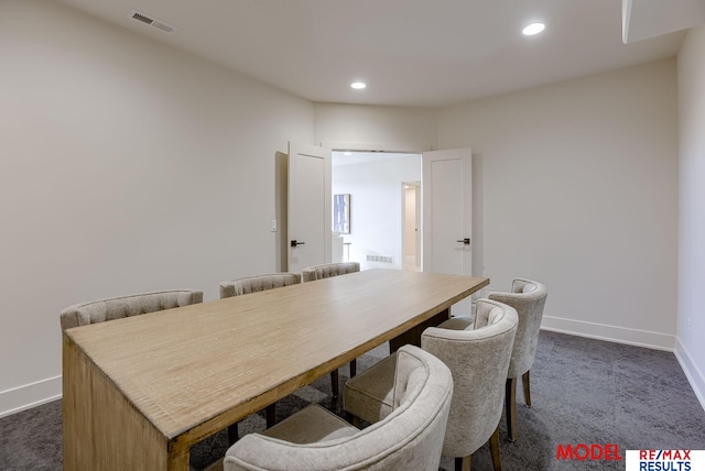 dining room featuring visible vents, baseboards, and dark carpet