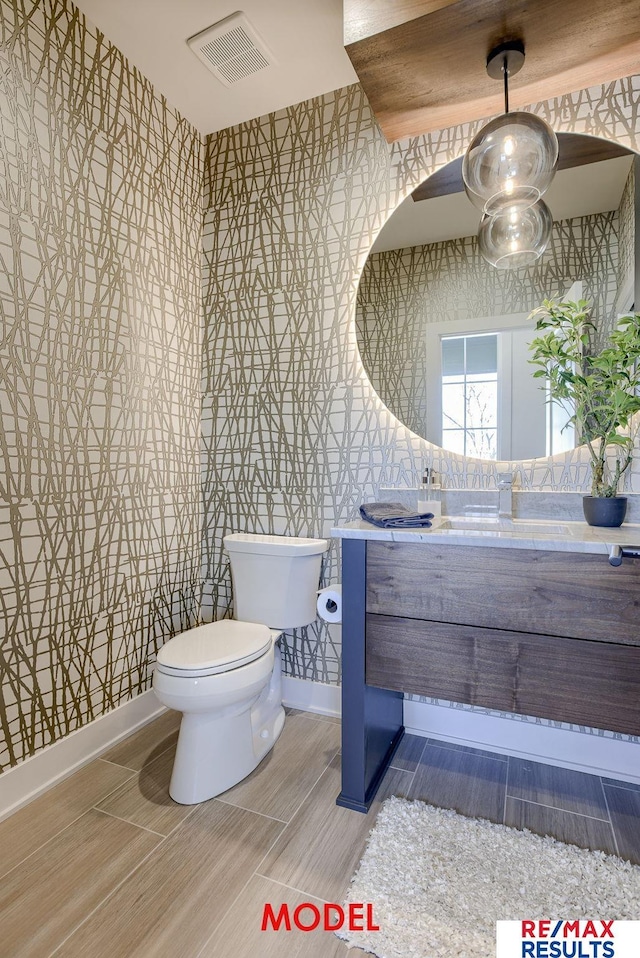 bathroom featuring vanity, a ceiling fan, visible vents, wallpapered walls, and toilet