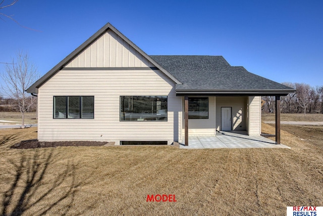 back of house featuring a patio area, a lawn, and a shingled roof