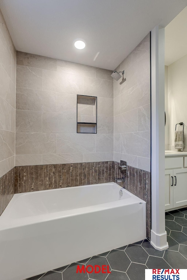 bathroom with tile walls, shower / washtub combination, vanity, and tile patterned flooring