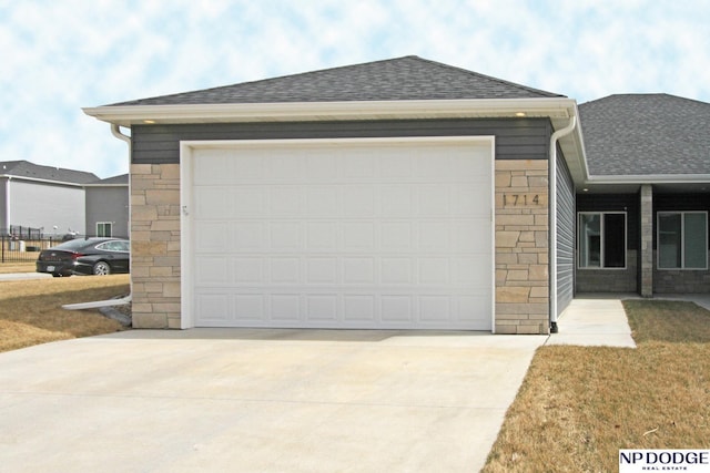 view of front facade featuring stone siding, driveway, and a shingled roof