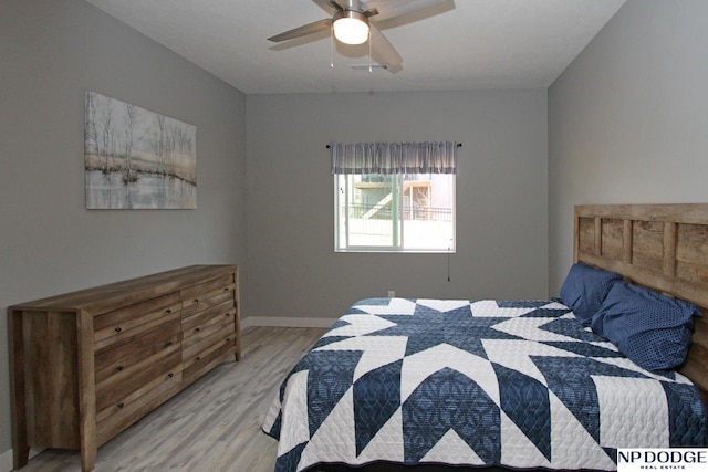 bedroom with baseboards, light wood-style floors, and a ceiling fan