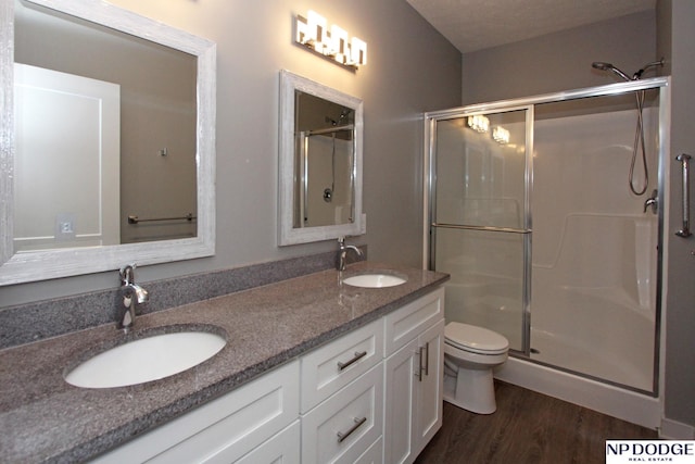 bathroom featuring a shower stall, wood finished floors, and a sink