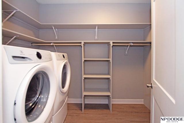 laundry room featuring laundry area, wood finished floors, baseboards, and separate washer and dryer