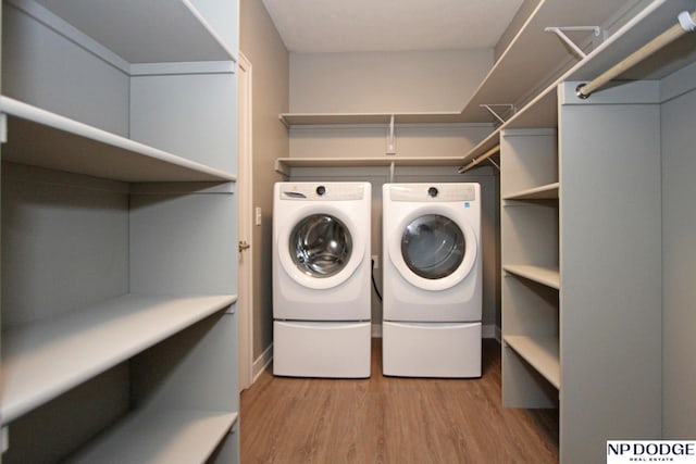 laundry room featuring washer and dryer, wood finished floors, and laundry area