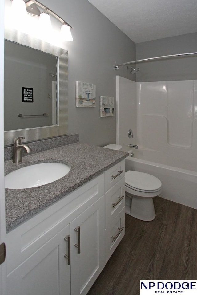 bathroom with vanity, bathing tub / shower combination, toilet, and wood finished floors