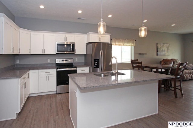 kitchen featuring a sink, open floor plan, stainless steel appliances, white cabinets, and dark wood-style flooring