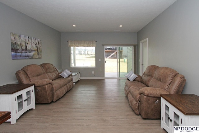 living area featuring recessed lighting, baseboards, and light wood-style floors