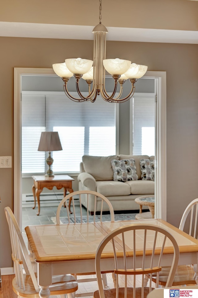 dining area featuring baseboards, plenty of natural light, and an inviting chandelier