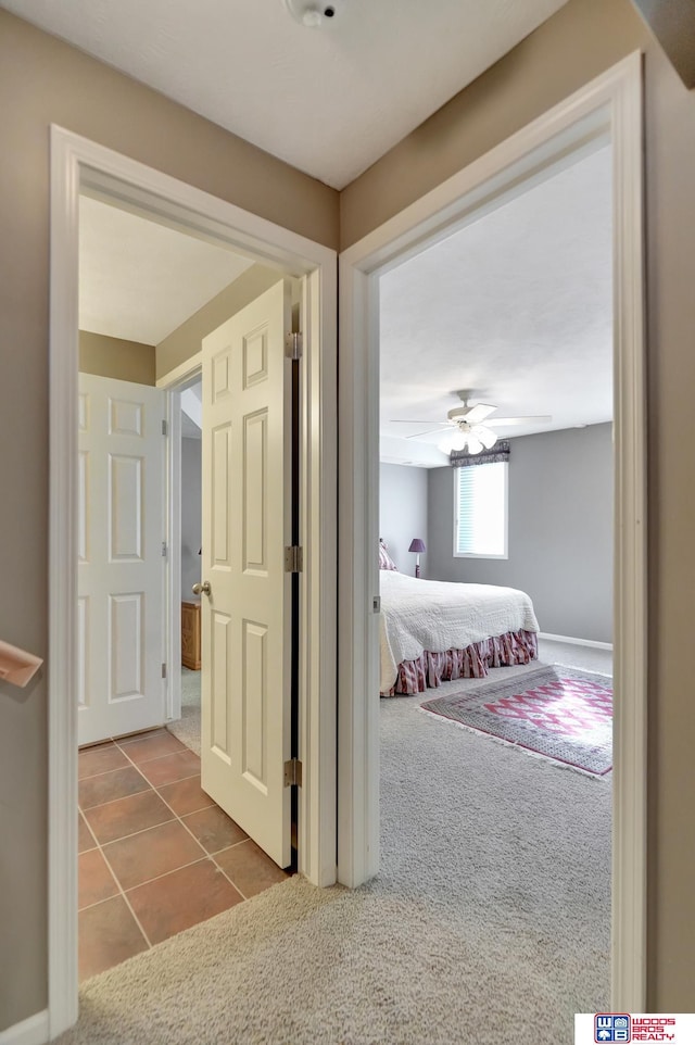 hallway with tile patterned floors and carpet