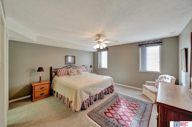 carpeted bedroom featuring baseboards and a ceiling fan