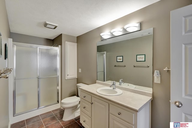 full bath featuring tile patterned floors, vanity, toilet, and a shower stall