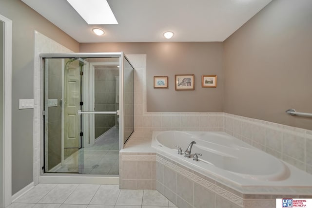 full bath with a shower stall, a garden tub, a skylight, and tile patterned floors