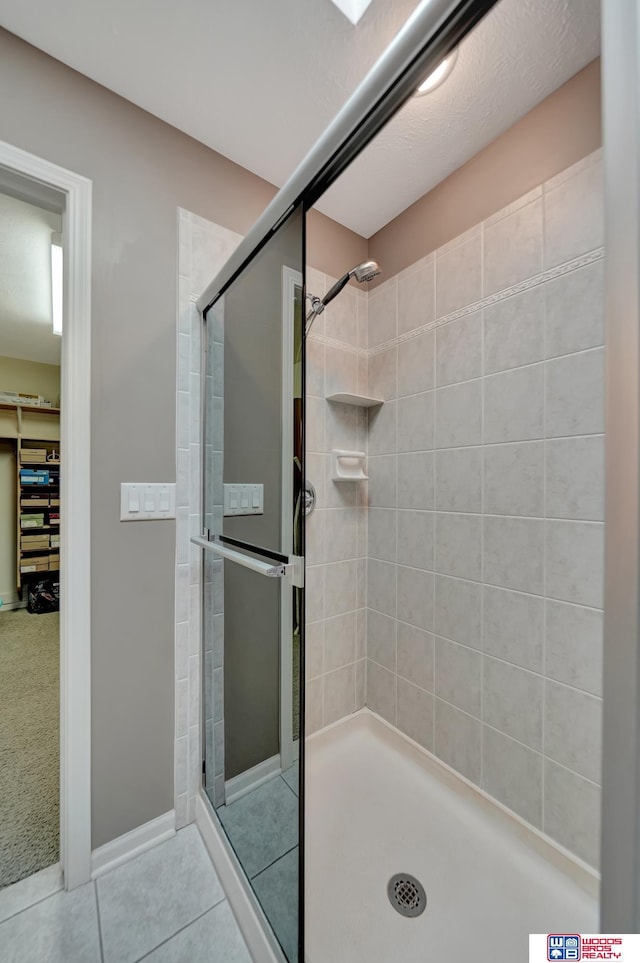 full bath featuring tile patterned floors and a shower stall