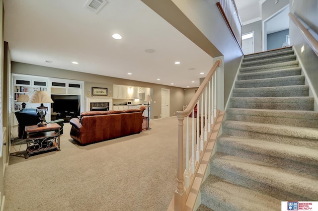 carpeted living area featuring visible vents, recessed lighting, and stairway