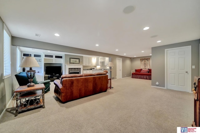 carpeted living area with recessed lighting, a fireplace, and baseboards