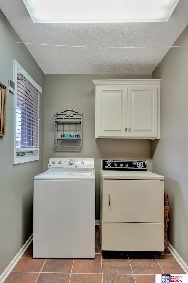 laundry area with tile patterned floors, baseboards, cabinet space, and separate washer and dryer