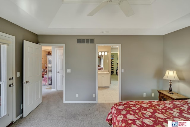 bedroom featuring visible vents, a ceiling fan, connected bathroom, baseboards, and light colored carpet