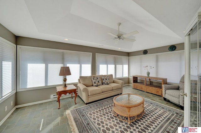 living area with stone finish floor, a ceiling fan, baseboards, and vaulted ceiling