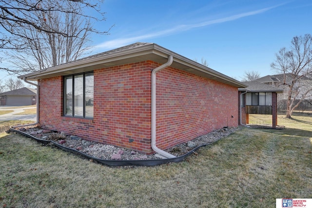 view of property exterior featuring a lawn and brick siding