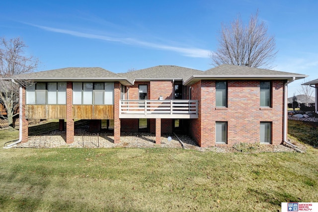 back of house with a lawn, brick siding, roof with shingles, and a wooden deck