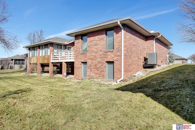 back of property featuring a yard, brick siding, central AC, and a wooden deck