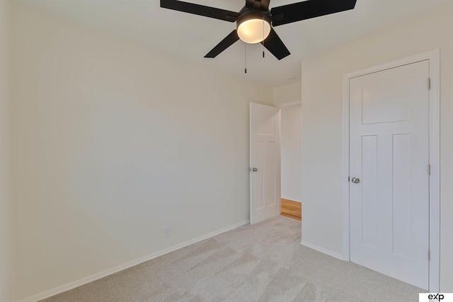 unfurnished bedroom featuring a ceiling fan, baseboards, and light carpet