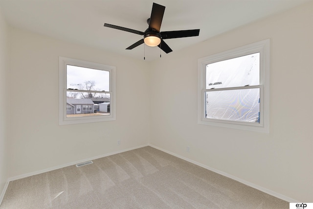 unfurnished room featuring light carpet, visible vents, ceiling fan, and baseboards