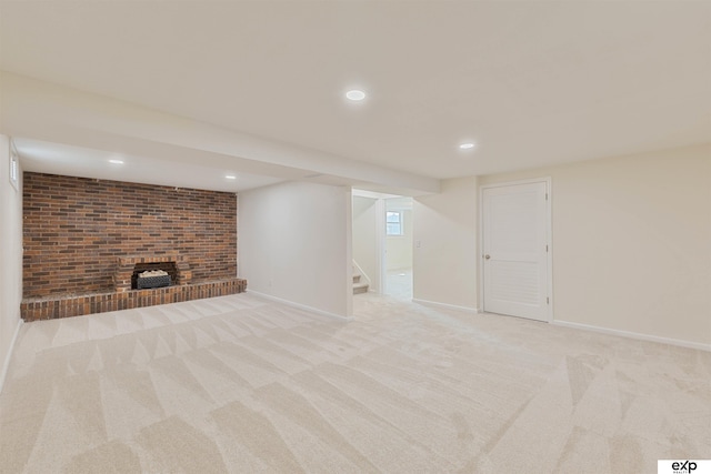 finished below grade area featuring light carpet, recessed lighting, stairway, baseboards, and a brick fireplace