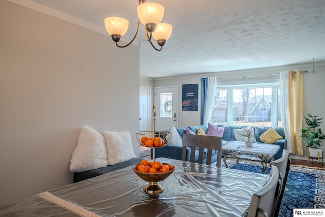 dining area with a textured ceiling, a chandelier, and crown molding