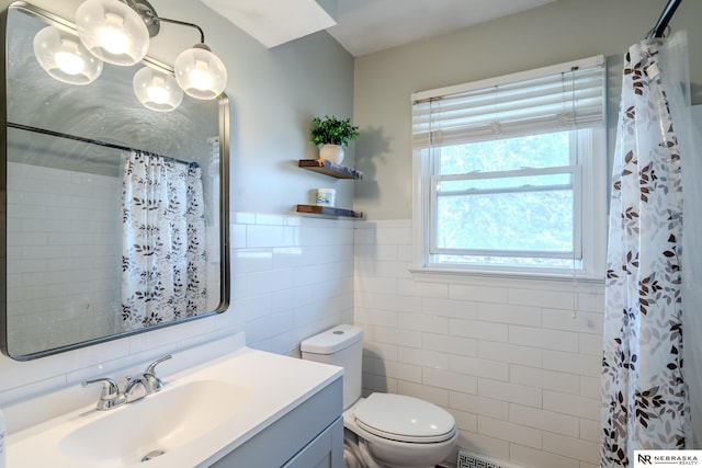 full bath with a wainscoted wall, toilet, curtained shower, tile walls, and vanity