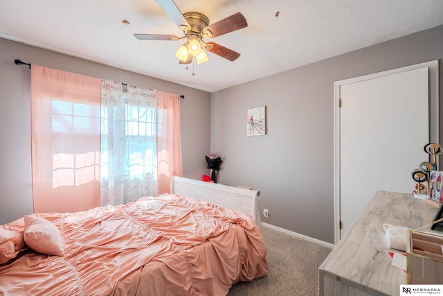 carpeted bedroom featuring a ceiling fan and baseboards