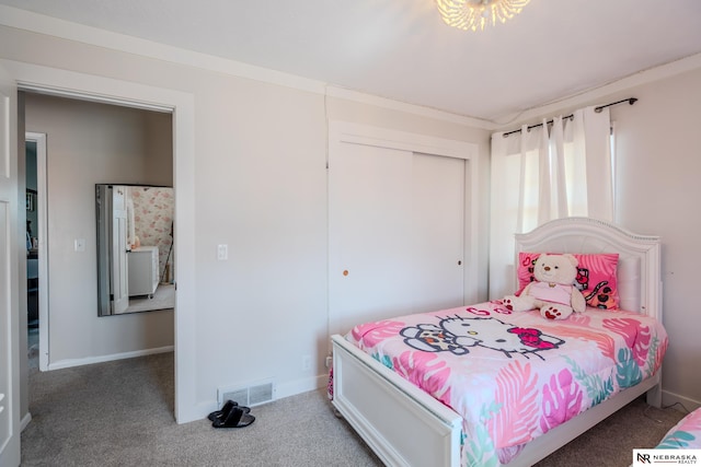 bedroom with a closet, visible vents, baseboards, and carpet