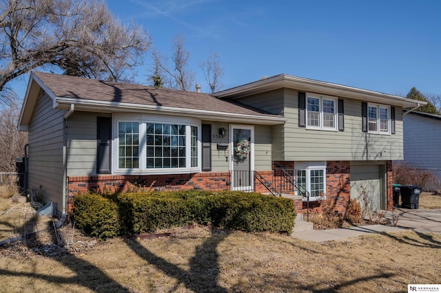 split level home with brick siding and an attached garage