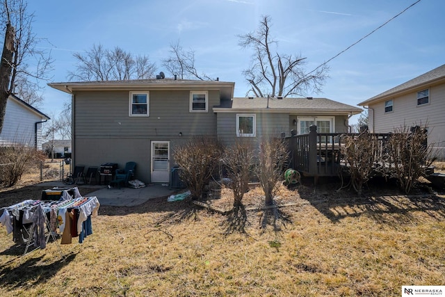 back of property with a wooden deck, a patio, and fence