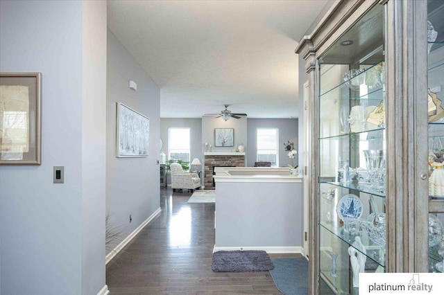 corridor with dark wood-style flooring and baseboards