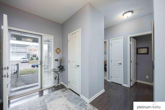 foyer entrance featuring baseboards and wood finished floors