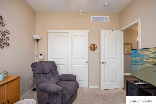 sitting room featuring visible vents, baseboards, and light colored carpet