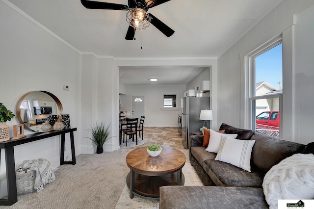 living room featuring light colored carpet, baseboards, and ceiling fan