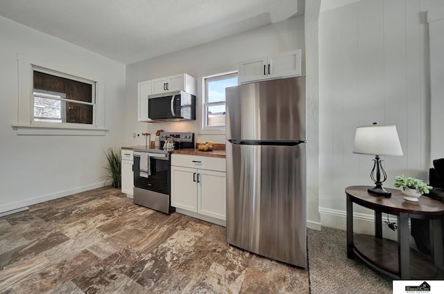 kitchen featuring white cabinets, stainless steel appliances, and baseboards