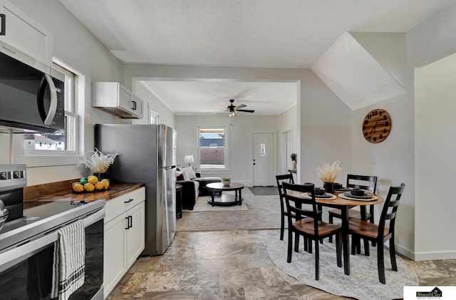 kitchen featuring white cabinetry, a ceiling fan, appliances with stainless steel finishes, and wooden counters